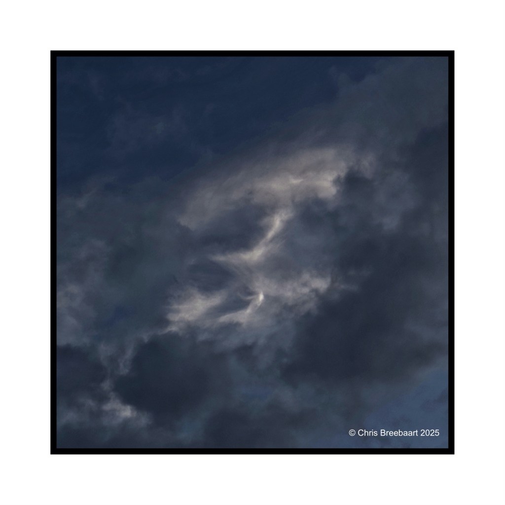 A dramatic sky featuring abstract cloud formations with a mix of dark and light shades.