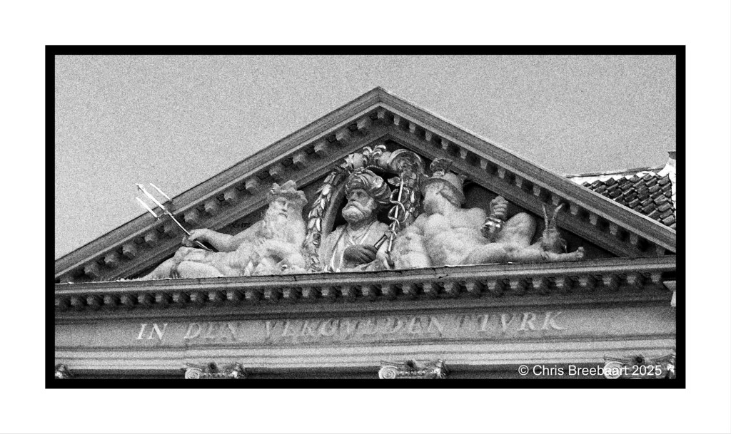Detail of decorative architectural relief featuring figures and inscriptions at the top of a historic building in Breestraat, Leiden, with emphasis on the former restaurant 'In den vergulden Turk.'