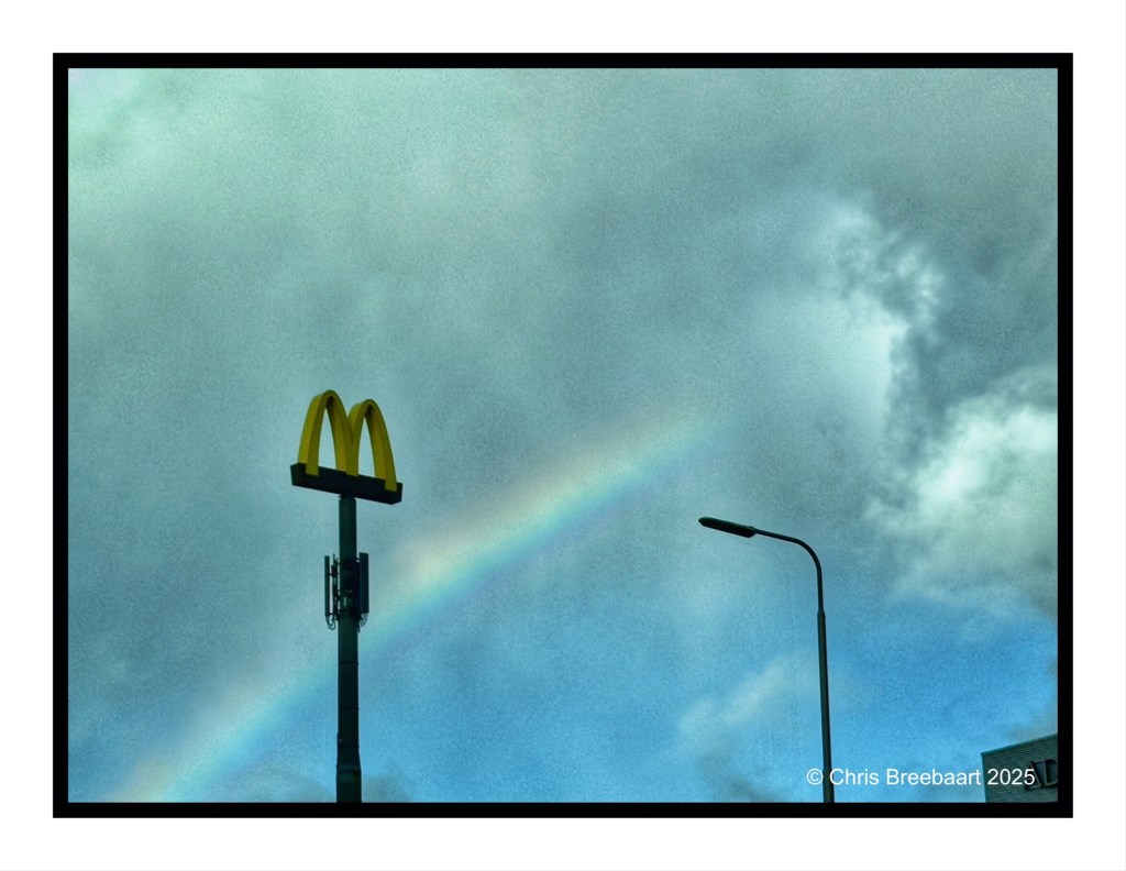 A McDonald's sign is visible against a backdrop of a rainbow and cloudy skies.