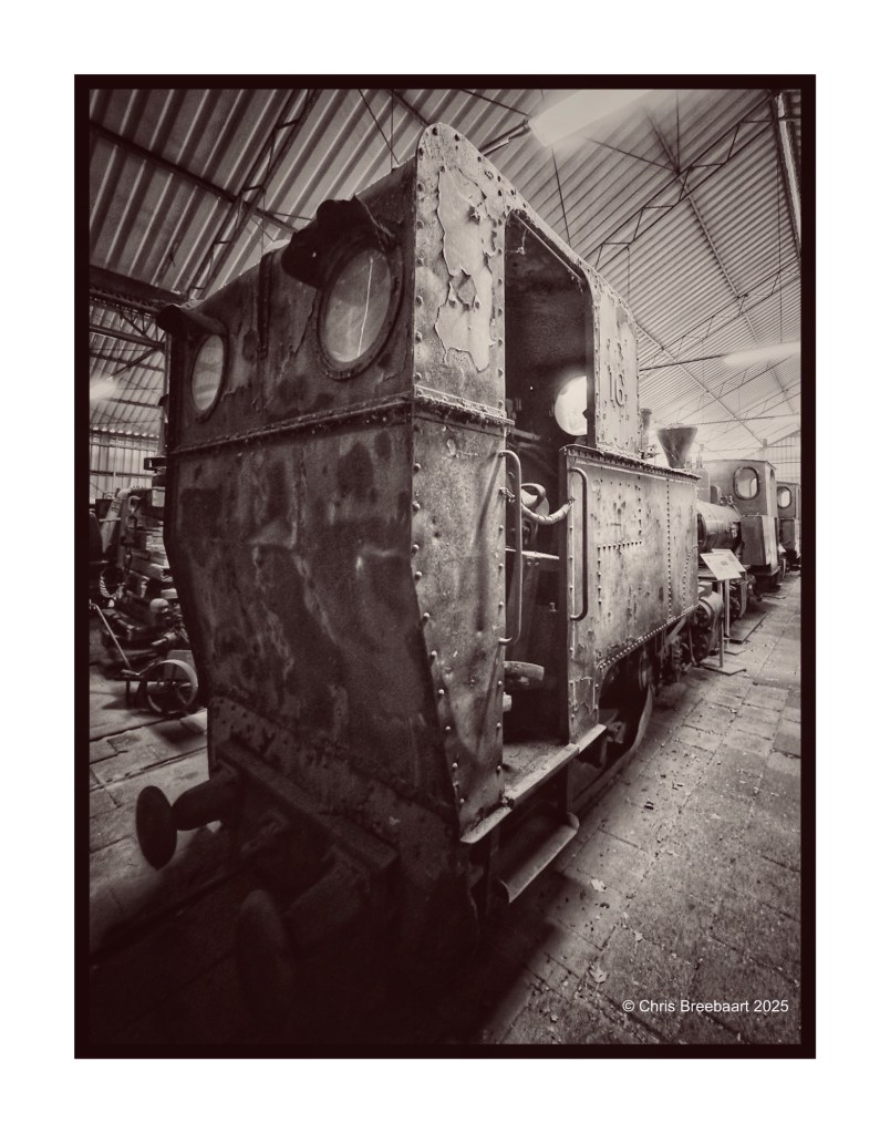 Close-up view of a vintage steam train locomotive in a museum, showcasing its weathered metal exterior and unique design.