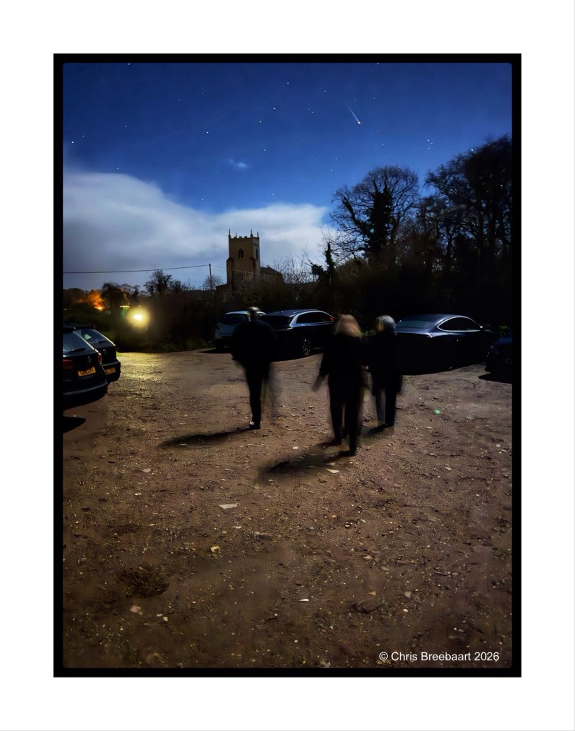 Four silhouetted figures walking in a dimly lit parking area at night, with a church tower in the background under a starry sky.