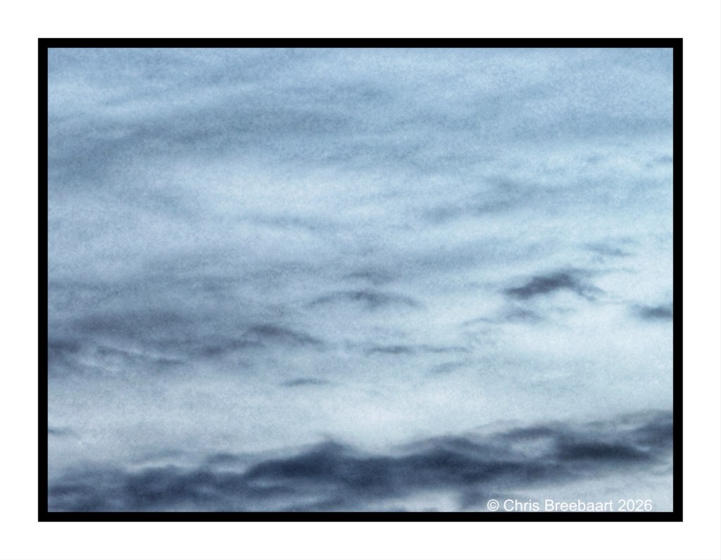 A textured sky with varying shades of blue and soft cloud formations.