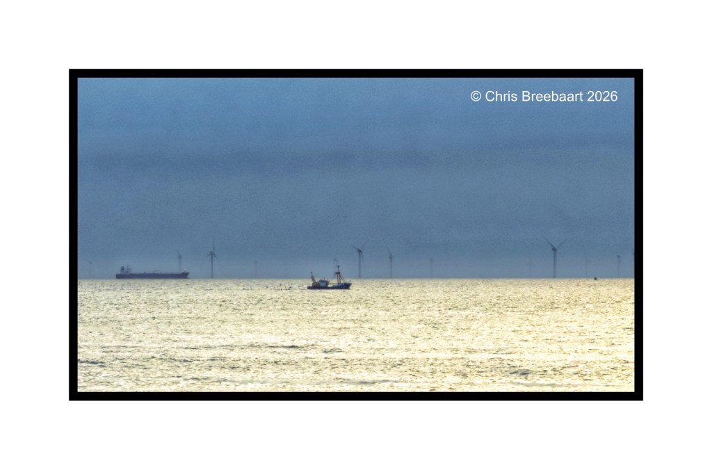 A serene seascape featuring a small fishing boat in the foreground, with a large cargo ship in the distance and wind turbines visible on the horizon, under an overcast sky.