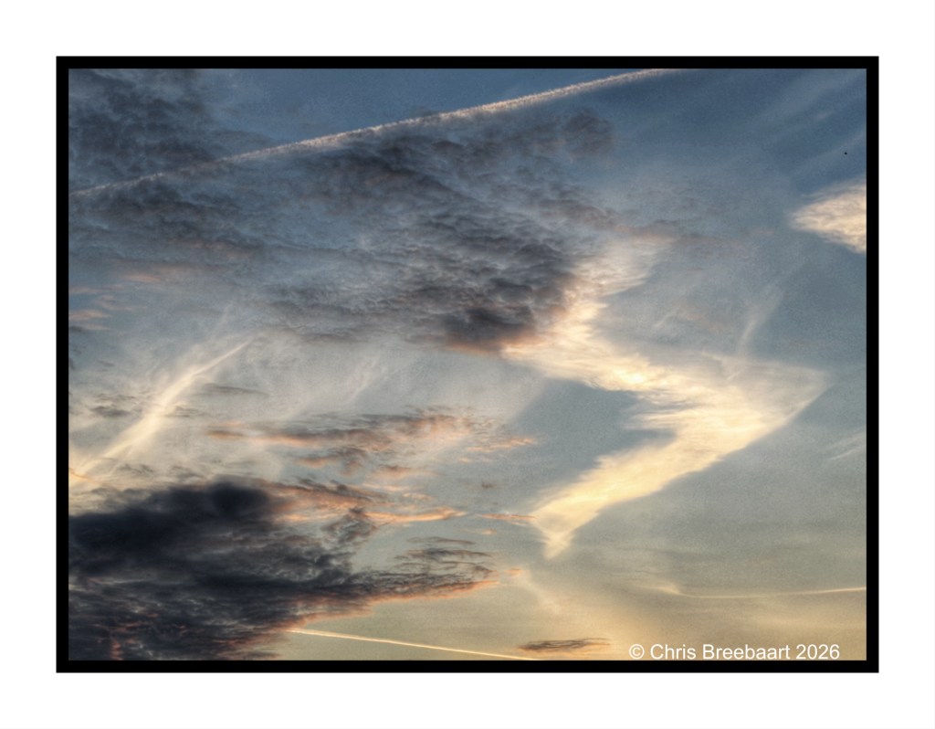 A beautiful sky filled with clouds, showcasing a gradient of colors from blue to soft orange and hints of pink, indicating either dawn or dusk.